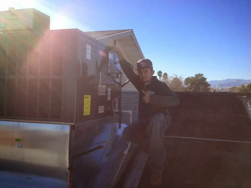 HVAC technician performing HVAC Inspection on a rooftop unit in Bristol
